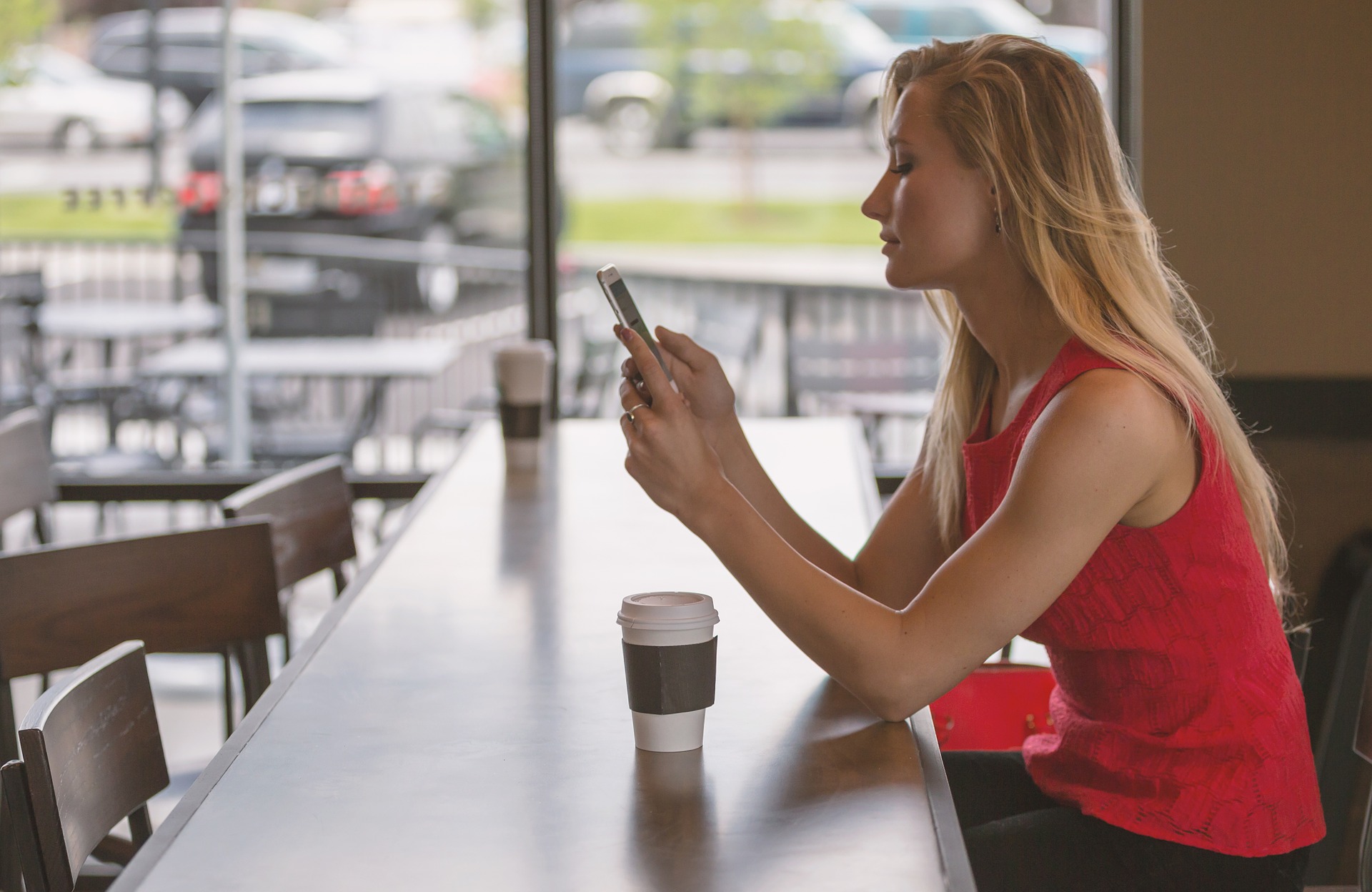 Woman in café looking at her mobile phone